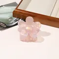 Detail of a light pink floral hair claw clip with a pearlescent finish on a retro background - PVC 7cm Flower - Iridescent Pink