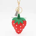Vue détaillée du porte-clés fraise rouge avec pompon gris et fermoir doré brillant - Fraise Rouge