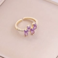 Dettaglio macro di anello regolabile in oro con tre zirconi viola rettangolari - Aperto Regolabile / Viola