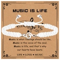 Detail view of white braided music bracelet with silver treble clef charm on gift card - Music Bracelet (White Rope) / White