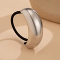 Close-up of polished silver metal cuff and black elastic band on beige background - Silver 1090573