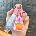 Adorable pink cartoon capybara keychain charm with a rotatable orange fruit face - Sitting Electroplated Style - Pink
