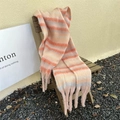 Detail of colorful striped winter scarf with long tassels on a wooden chair - Striped Pink