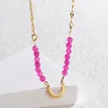Dettaglio macro di collana in acciaio dorato con perline rosa e ciondolo a raggiera - Perline Magenta