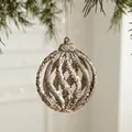Christmas hollow spiral ball ornament with silver glitter hanging on a pine tree branch - Hollow Spiral Ball