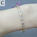 Detail of gold zircon bracelet featuring rectangular crystals and paved diamonds on wrist - Triple Rectangular Stone Clasp Style (C)