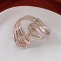 Detail of a fluid sculptural silver cuff bracelet displayed on a white ceramic plate - Silver