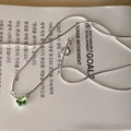 Detailed macro shot of a green heart zircon pendant on a silver snake chain necklace - Green Heart Style (MY34858)