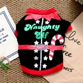 Detailed view of the Naughty Elf Christmas dog t-shirt flat laid on a textured mat - Candy Cane