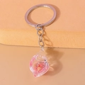 Detailed macro view of conch shell keychain with pink liquid and micro shell inside - Pink