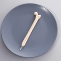 Unique bone-shaped ballpoint pen in cream white finish on a matte grey tray - Style A (Femur Shape)