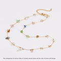Détail du collier en chaîne dorée avec pierres naturelles colorées sur fond blanc - Collier