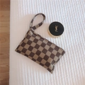 Detailed close-up of corduroy checkered mini pouch with handle in beige and brown colors - Brown Checkered