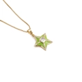 Macro detail of 18k gold plated star pendant with green enamel and square zircon - Green