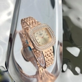 Macro shot of rose gold square watch with double diamond-encrusted bezel on reflective surface - Rose Gold