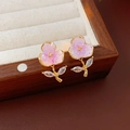 Dettaglio degli orecchini a fiore in cristallo rosa con petali placcati oro e zirconi lucidi - Viola