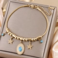 Detail view of gold titanium steel bracelet with star charms and blue turquoise stones - Gold B-253G (Star/Blue Stone)