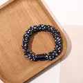 Close-up of a navy blue polka dot scrunchie with a decorative resin buckle on wood - Satin Polka Dot Navy Blue