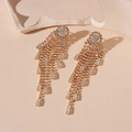 Detailed view of long gold tassel earrings with zircon studs on a stone block - Gold Zirconia Tassel Earrings