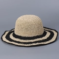 Dettaglio del cappello di paglia intrecciato con texture fine e strisce - Beige