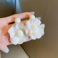 Detailed macro view of white fabric flower earrings with elegant silk texture and pearl center - Cream Mesh Flower