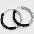 Close-up of oversized hoop earrings featuring sparkling black and silver glitter texture - Black & Silver Two-Tone