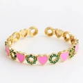 Detail of gold-plated open ring with pink enamel hearts and green zircon stones - Heart Pink
