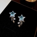 Detailed macro shot of meteor star earrings with blue crystals and silver finish - Star Tassel Style / Blue Ear Hook
