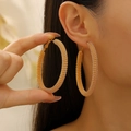 Aros dorados con textura de malla mostrados en una modelo para un look de moda elegante - Pendientes de Aro Dorados Texturizados (WG-0377) / Dorado