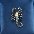Baroque scorpion brooch in antique gold finish with blue rhinestones on satin - Scorpion Style (XD9235)