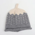 Detailed close-up of knit baby beanie with white heart jacquard pattern and contrast colors - Grey Beige