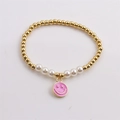 Detail of beaded bracelet with gold copper beads, white pearls and pink smiley face charm - Pink