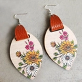 Böhmische Tropfenohrringe aus Holz mit Sonnenblumenmuster auf grauem Hintergrund - Stil mit Sonnenblumen, Gänseblümchen und braunem Leder