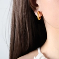 Elegante 18K vergulde C-vormige ster-zirkonia oorringen getoond op een model - Goud