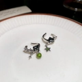 Detail van zilveren kattenoorbellen met groene ster- en kraalhangers op keramiek bord - Zwarte Kat Groene Ster Stijl (HE28633-HE28636-HE28637) / Zilver