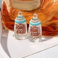 Macro shot of two miniature resin baby bottles with 150ml scale markings for DIY crafts - Blue