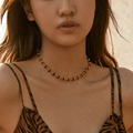 Close-up of a vintage gold plated necklace with dark brown beads on a model - 18K Gold