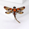 Vintage dragonfly brooch with amber crystals on a silver metal base, professional still life - Coffee