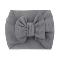 Detail of grey textured fabric baby headband featuring a large soft decorative bow - Gray