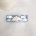 Blaue Haarspange mit Wolkenmuster auf weichem weißem Stoff mit einer Kerze im Hintergrund - Blaue Wolke - Federclip