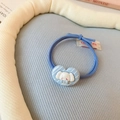 Vue macro d'un chouchou bleu clair avec un adorable charm en résine en forme de cœur - Élastique À Cheveux - Bleu (cordon Tressé)