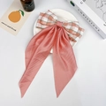 Dettaglio di un fiocco a quadri rosa con lunghi nastri di raso su un piatto - Rosa