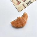 Phone socket grip featuring a realistic resin croissant bread in caramel brown finish - Croissant Stand