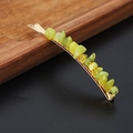 Elegant metal hair clip featuring natural green crystal stones on a wooden surface - Korean Jade Gold