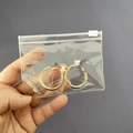 Golden round hoop earrings packed in a clear PVC self-sealing transparent jewelry bag - Slider Bag 10.5*7.5cm
