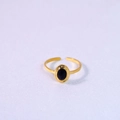 Close-up of gold open ring featuring a polished oval black natural stone inlay - Black Agate