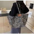 Stylish large leopard print canvas tote bag with brown handles worn by a female model - Coffee Leopard