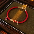 Macro shot of red braided rope bracelet with gold snake charm and ruby gemstone detail - Zirconia Wrap Snake Style (HB5012-11)