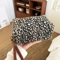 Plush leopard print makeup bag with a brown wrist strap and fuzzy animal fur texture - Handheld Plush Beige Coffee Leopard