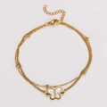 Detailed view of dual-layer golden butterfly anklet with white shell charm on white background - Bracelet